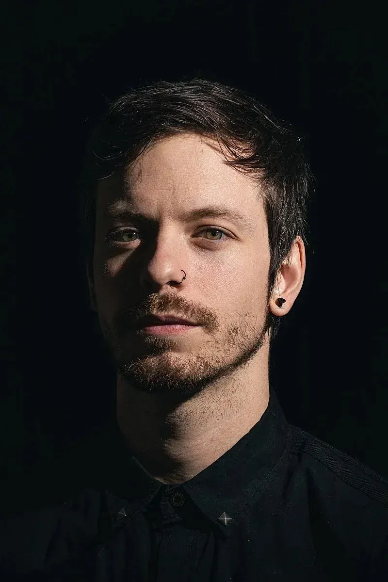 James Zechman looking towards the camera with a black smokey background